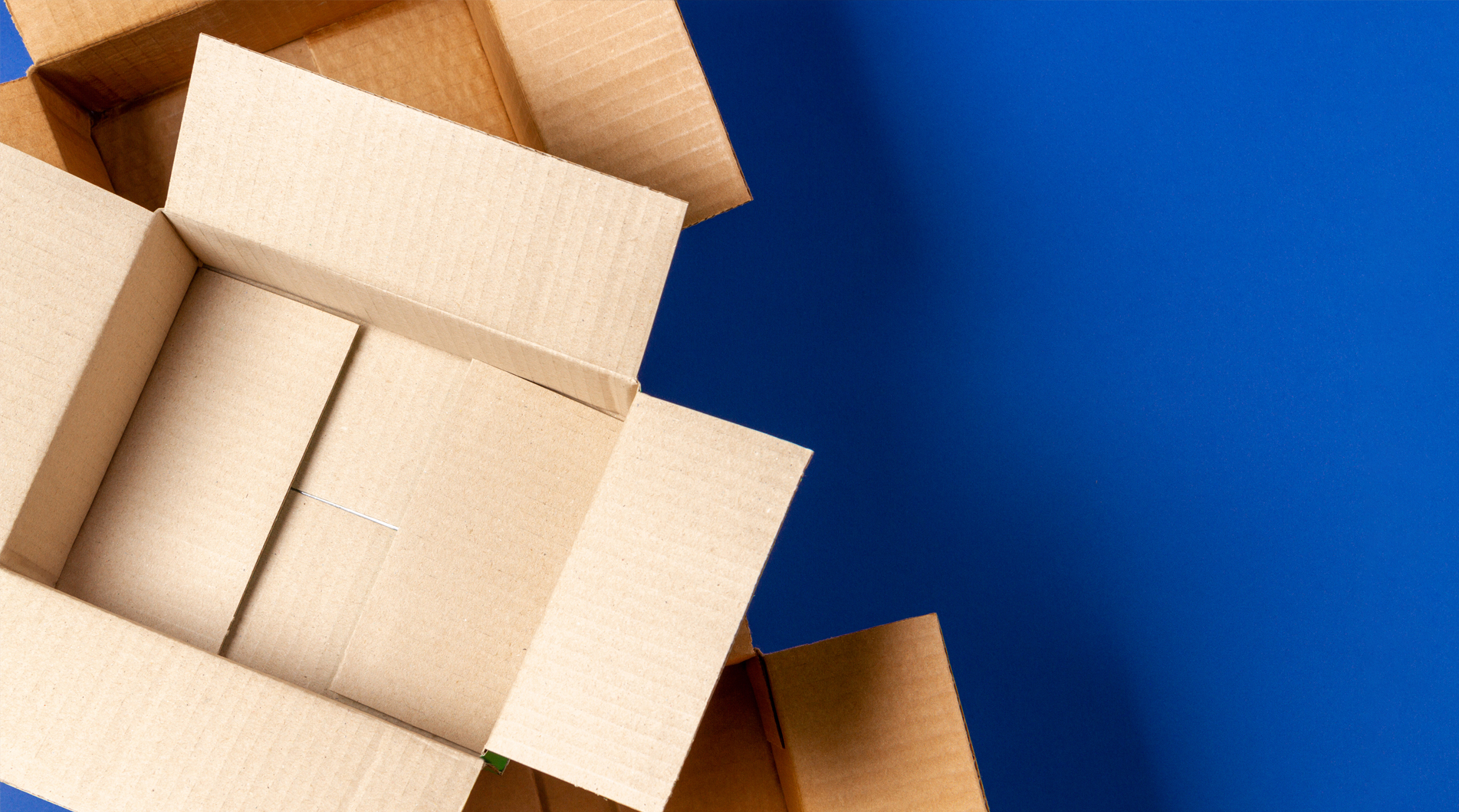 image showing empty open cardboard boxes on blue background